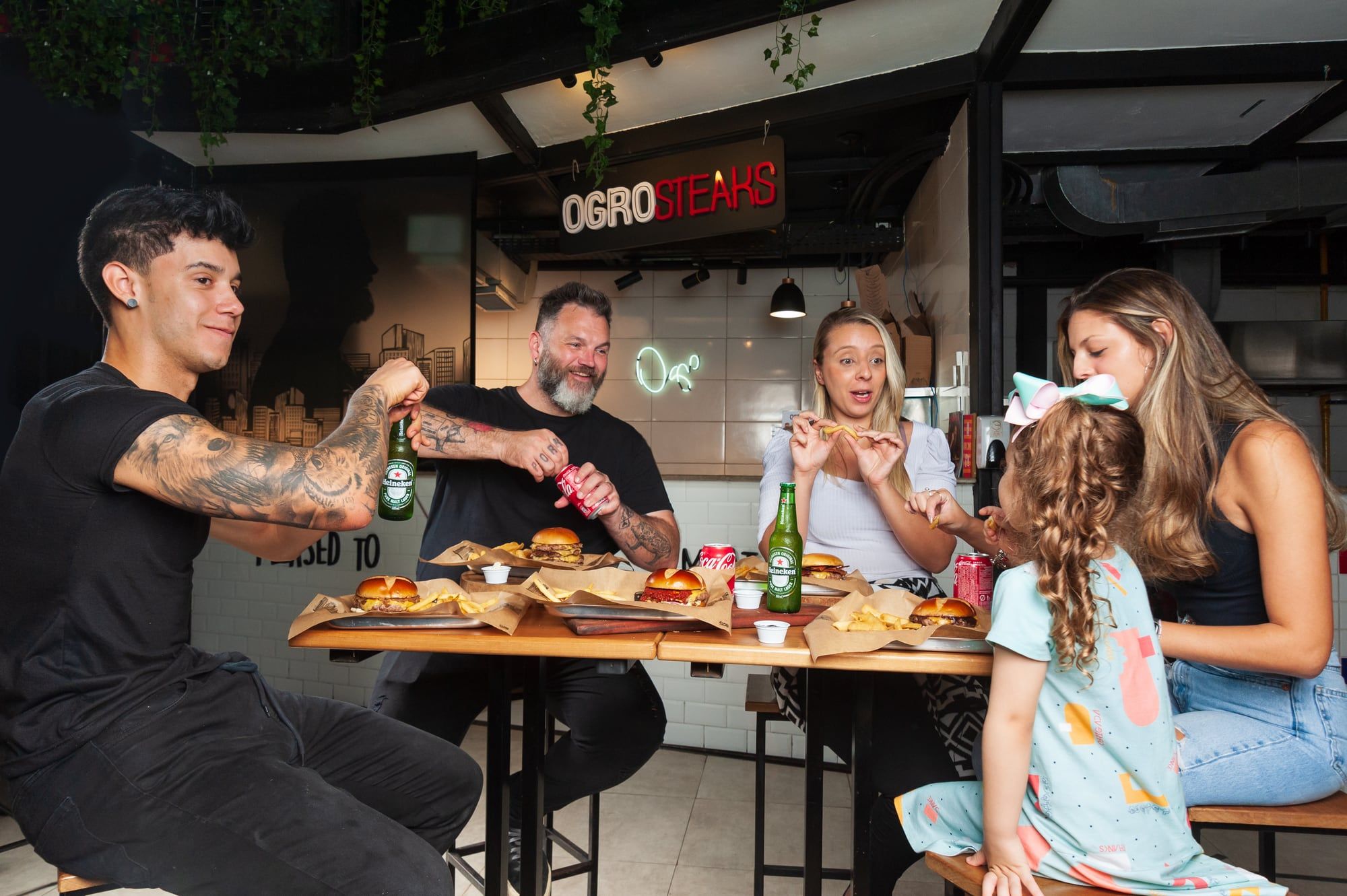 Família comendo hambúrgueres no salão de uma loja da Ogro Steaks